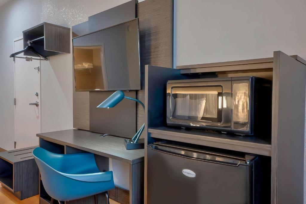 a kitchen with a microwave and a blue chair at Motel 6-Denison, TX in Denison