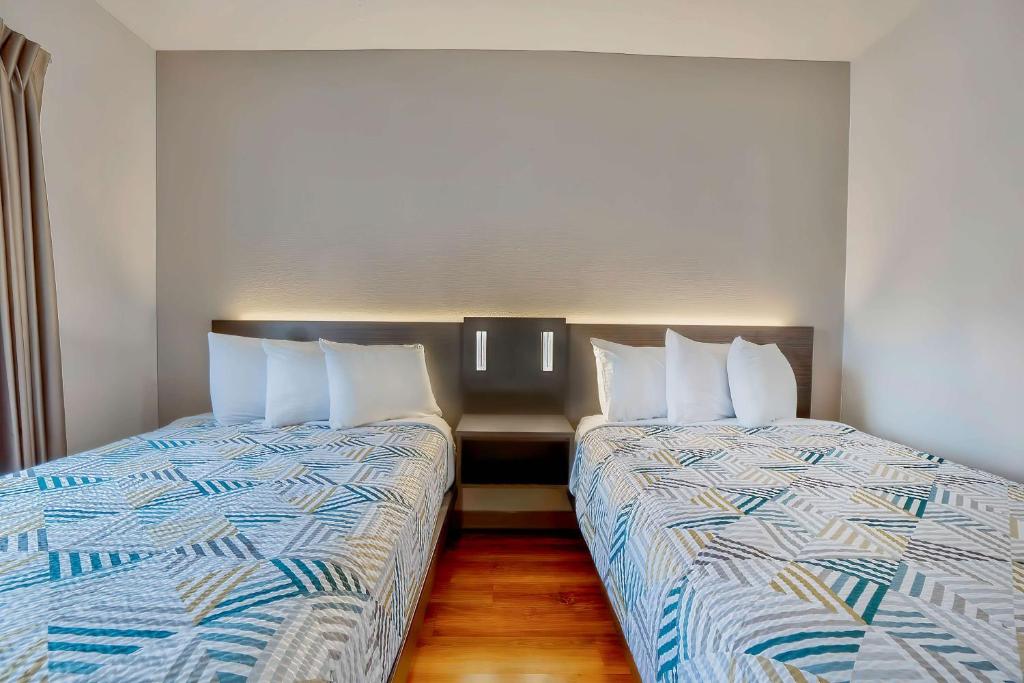 two beds sitting next to each other in a room at Motel 6-Denison, TX in Denison