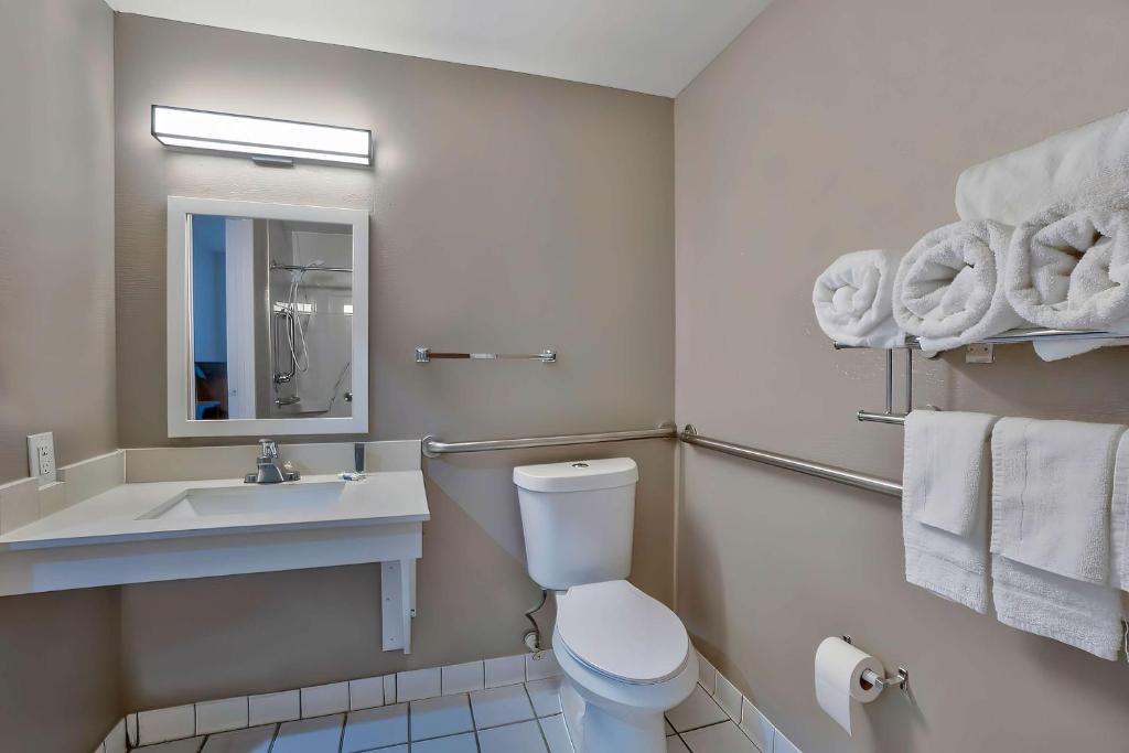 a bathroom with a toilet and a sink and a mirror at Motel 6-Denison, TX in Denison