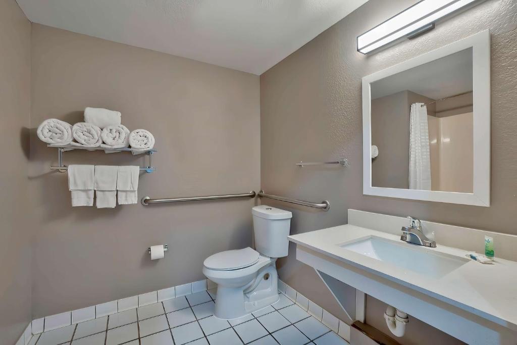 a bathroom with a toilet and a sink and a mirror at Motel 6-Denison, TX in Denison