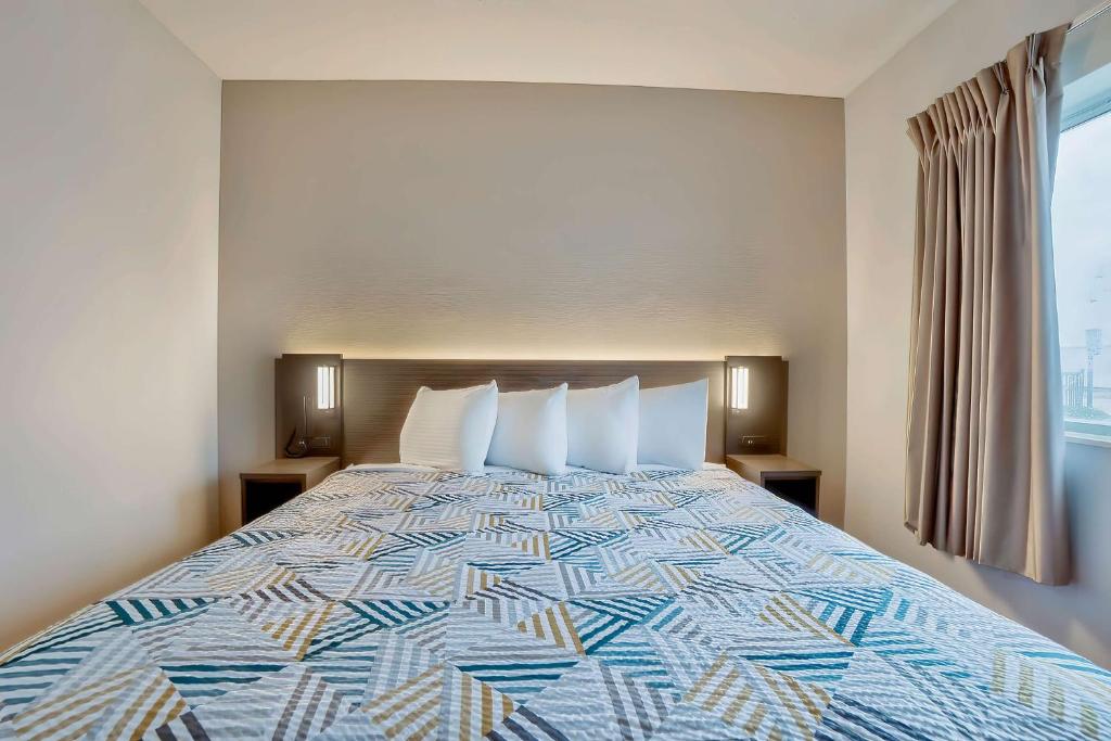 a large bed in a hotel room with a large window at Motel 6-Denison, TX in Denison