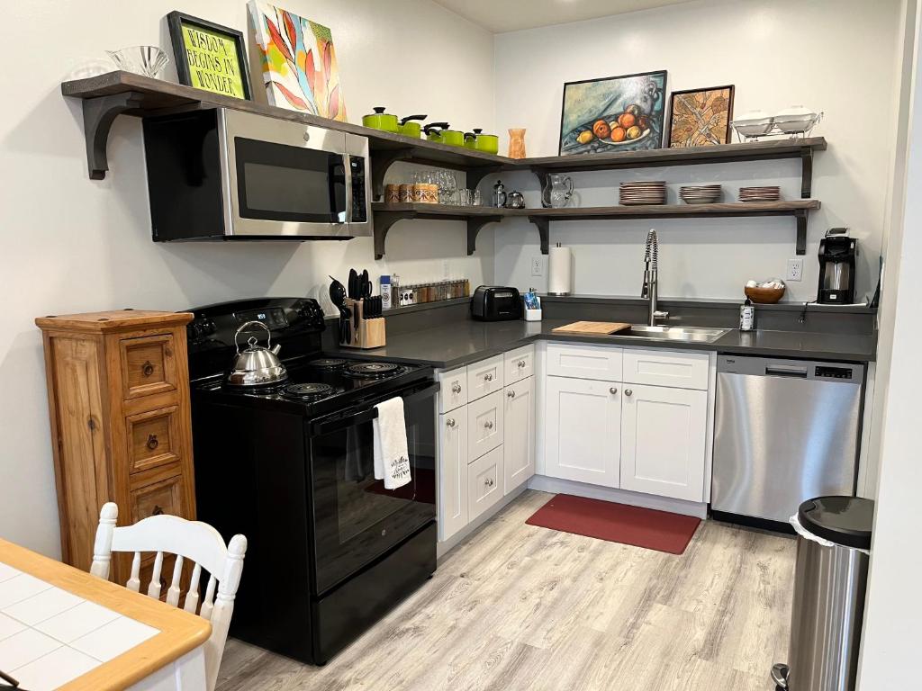 uma cozinha com um fogão preto e um micro-ondas em Cute 1 bedroom Ohana 10 miles from Eugene em Creswell