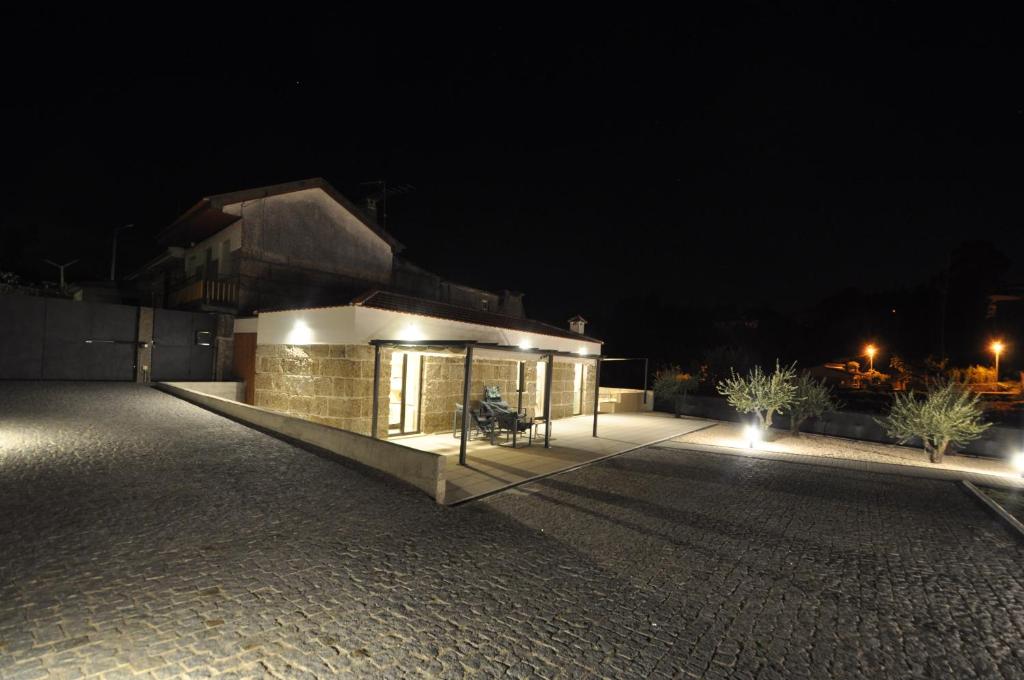 un edificio con una panchina di fronte ad esso di notte di Olival da Seara a Marco de Canaveses