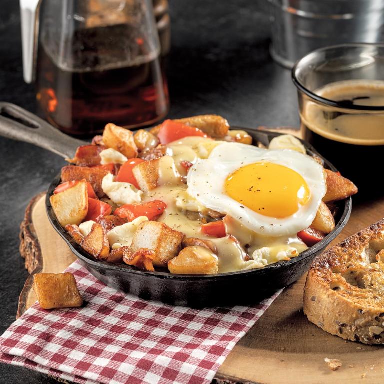 a frying pan with an egg on top of food at AUBERGE et BISTRO NAMASTÉ in Lachute
