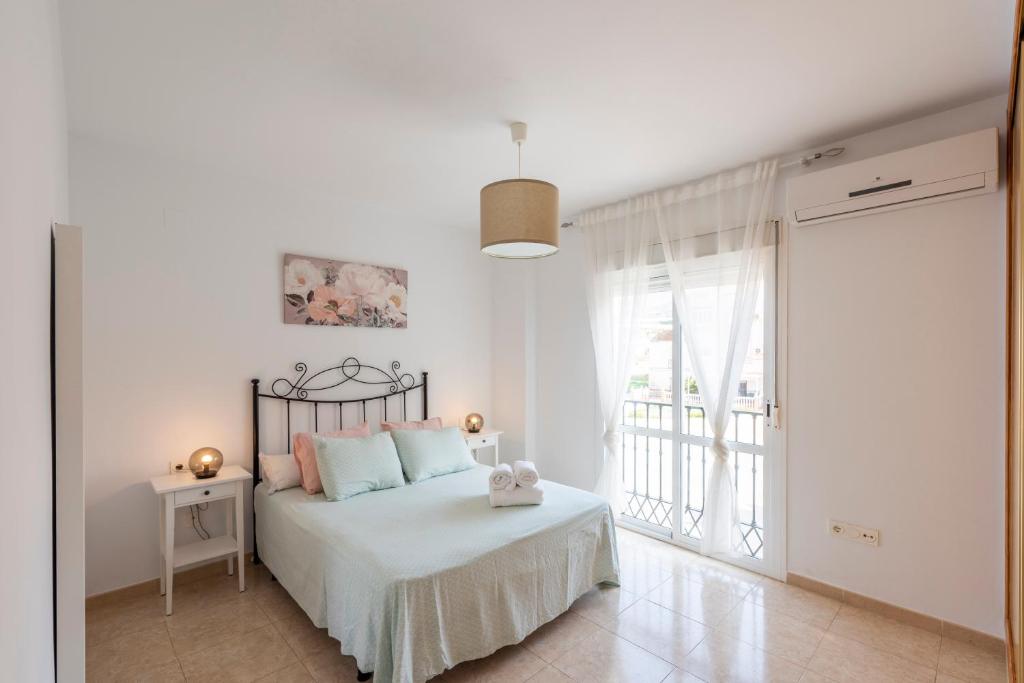 Habitación blanca con cama y ventana en Apartamento Coral, en Torrox Costa