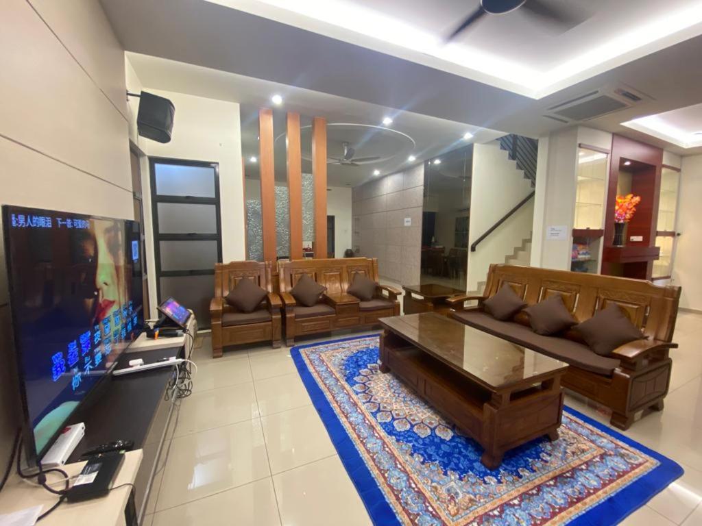 uma sala de estar com dois sofás e uma televisão em Villa near SPICE Arena 3BR 15PAX with KTV Pool Table and Kids Swimming Pool em Bayan Lepas