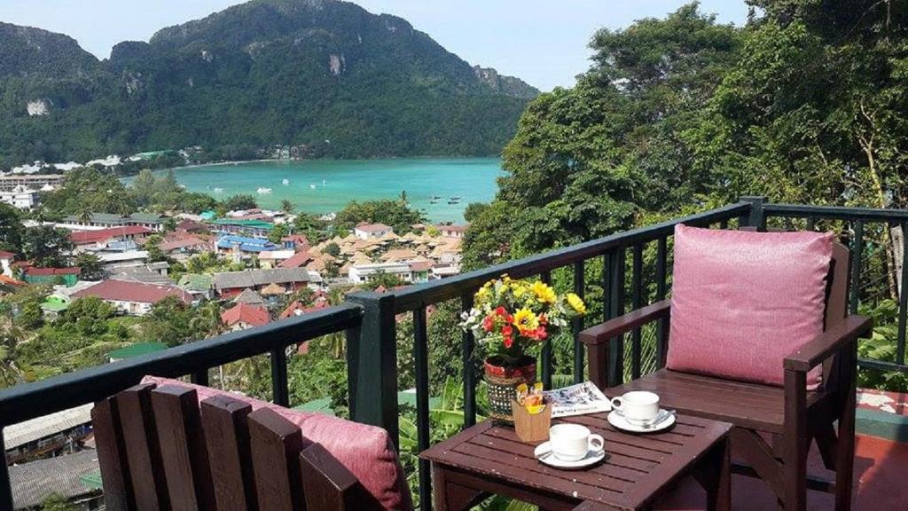 a table and chairs on a balcony with a view of the ocean at Phi Phi Arboreal Resort in Phi Phi Don