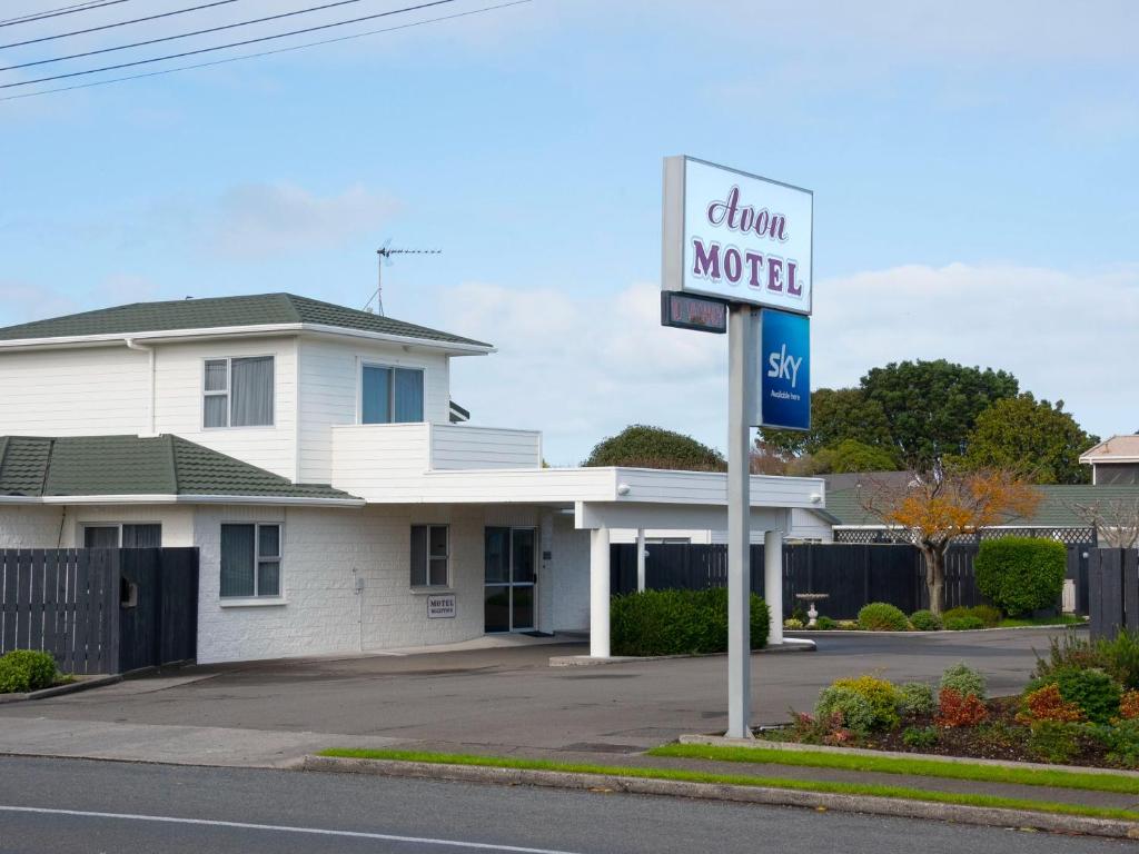 a slow motel sign in front of a house at Avon Motel in Hawera