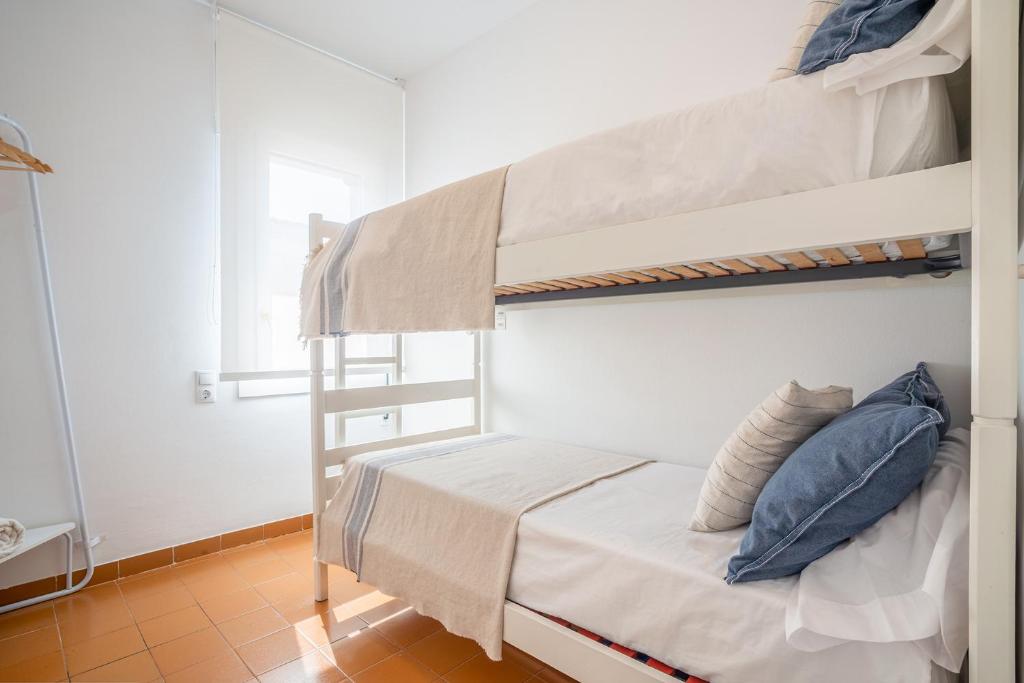 A bed or beds in a room at Beach House Cambrils Apartamento en Primera Línea de playa