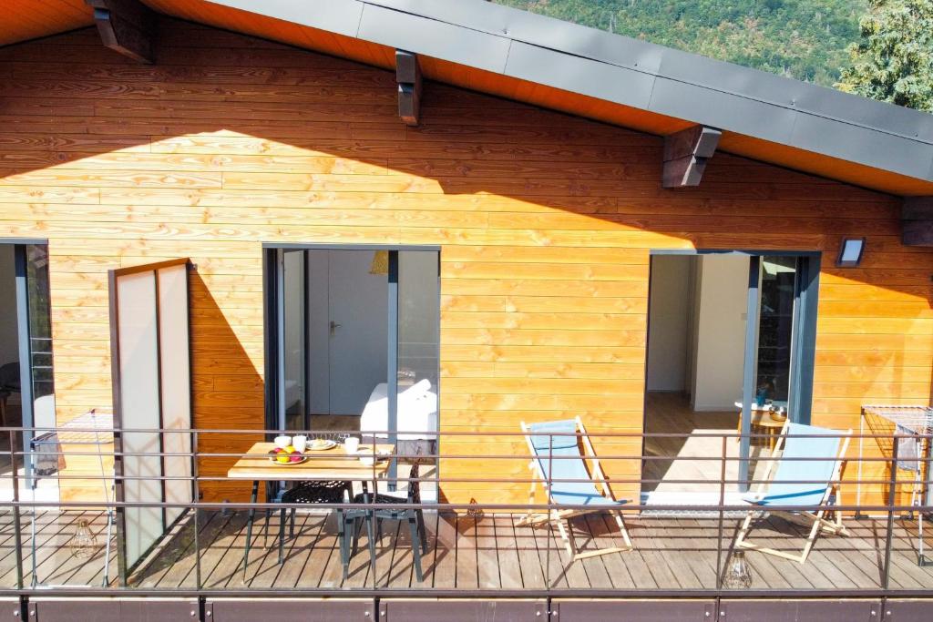 ein Holzhaus mit einem Tisch und Stühlen auf einer Terrasse in der Unterkunft La Tournette superb quiet apartment 300 meters from the lake in Sévrier