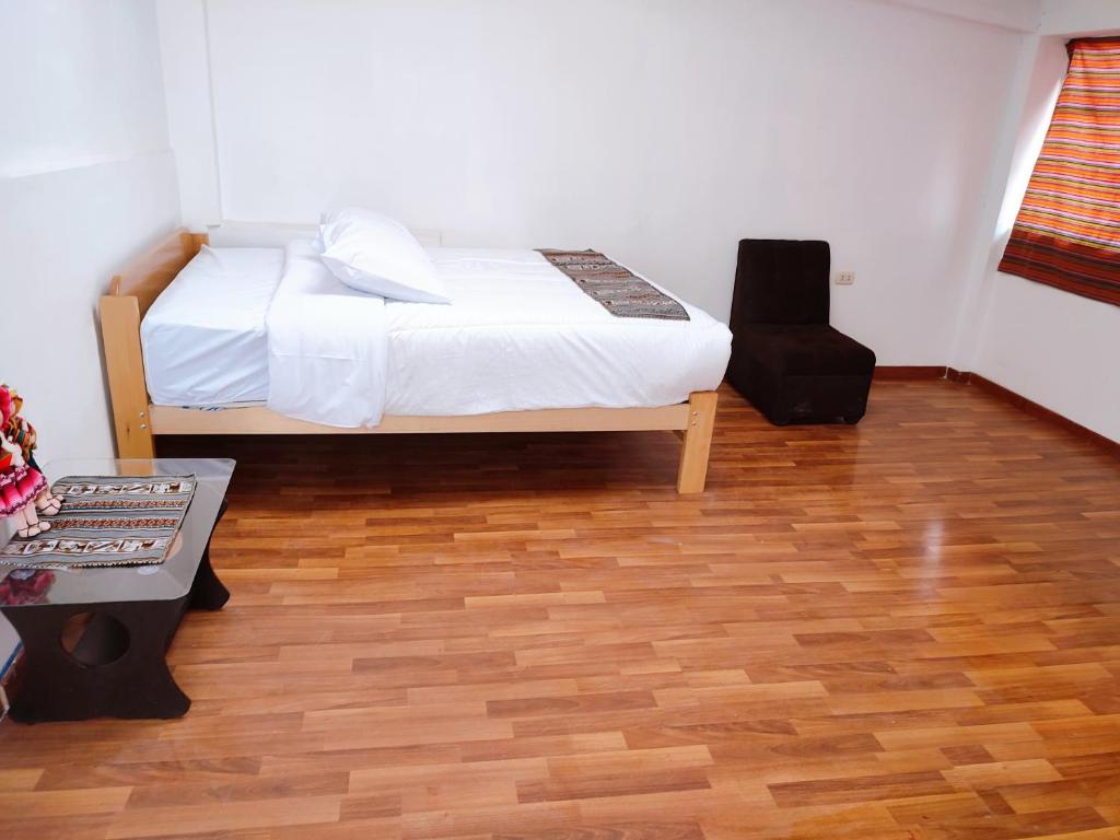 - une chambre avec un lit et du parquet dans l'établissement ENEDE HOSTEL, à Cusco