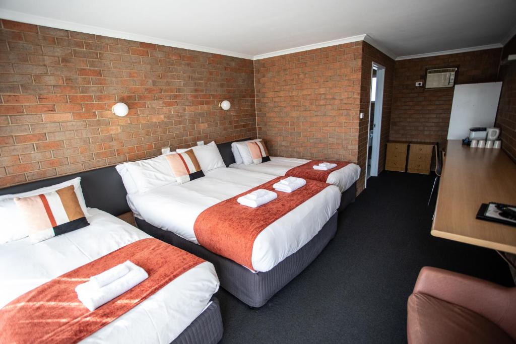 a hotel room with two beds and two lamps at Moama Motel in Moama