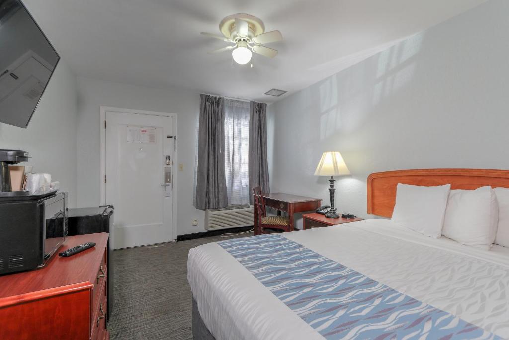 a hotel room with a bed and a flat screen tv at Belle Aire Motel - Downtown Convention Center - Gatlinburg in Gatlinburg