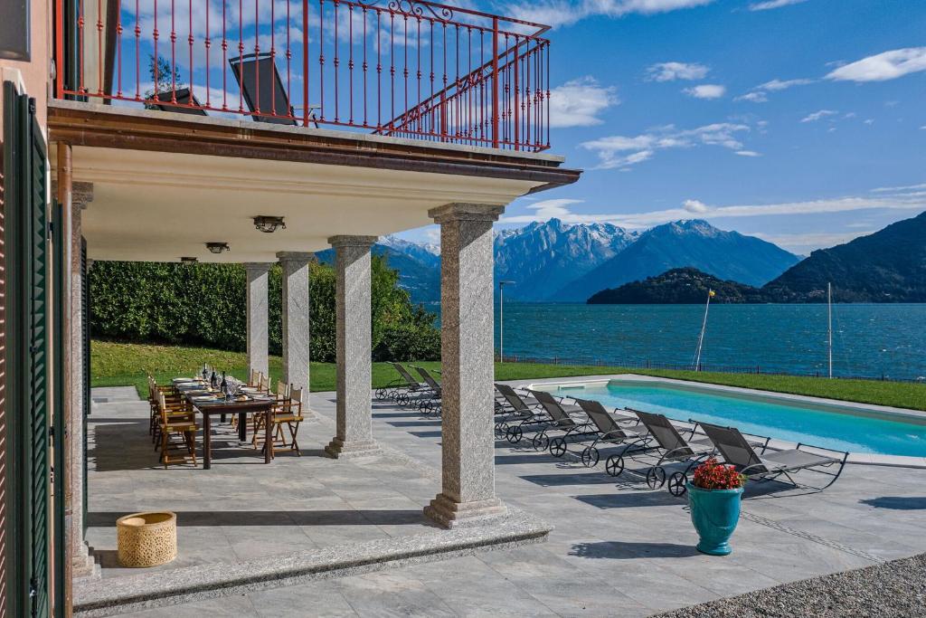 Un patio con mesa y sillas y una piscina. en Villa L'angelo Del Lario, en Carlazzo