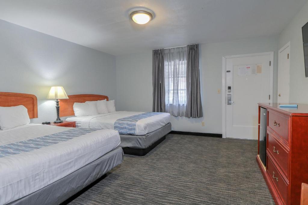 a hotel room with two beds and a dresser at Belle Aire Motel - Downtown Convention Center - Gatlinburg in Gatlinburg