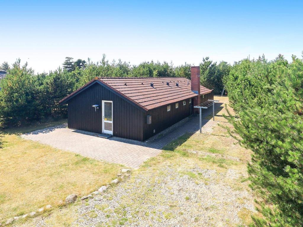 ブラーバンドにあるThree-Bedroom Holiday home in Blåvand 87の庭に扉のある小さな建物