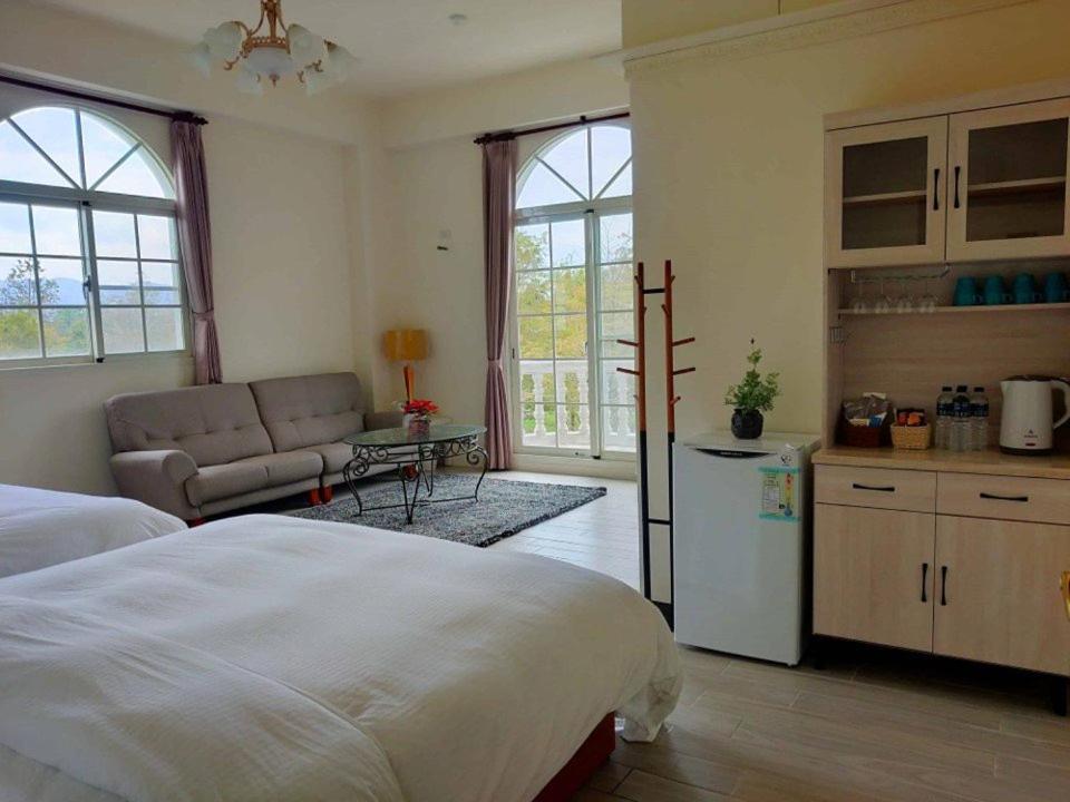 una camera con letto e una cucina con divano di 谷築石苑 a Fengli