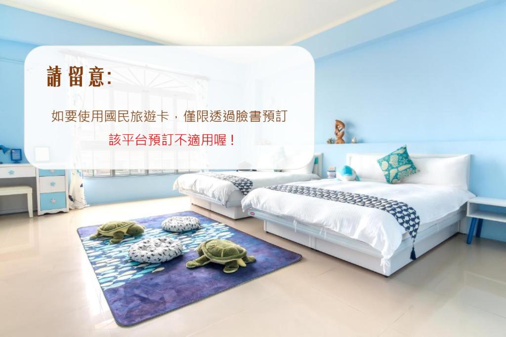 a bedroom with two beds and two turtles on a rug at Ciao Life B&amp;B in Taitung City