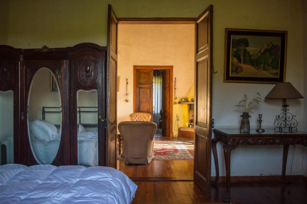 1 dormitorio con cama y espejo grande en Estancia Rincón del San Francisco, en Paysandú