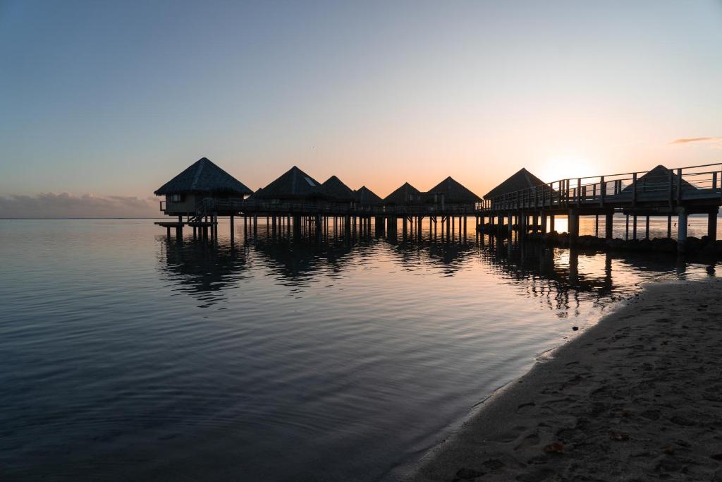un groupe de cabanes sur un quai dans l'eau dans l'établissement Douceur Tropicale Proximité plage et commerces, à Punaauia