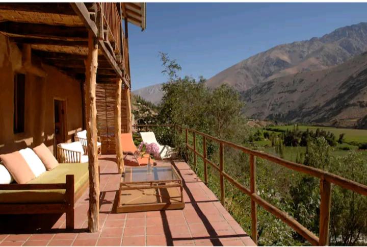 Ladera Loft Pisco Elqui في بيسكو إلكي: شرفة منزل مع طاولة وكراسي