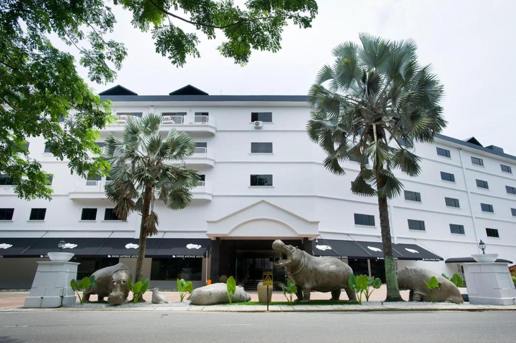 a building with statues of animals in front of it at SWISS AVENUE HOTEL in Sungai Petani