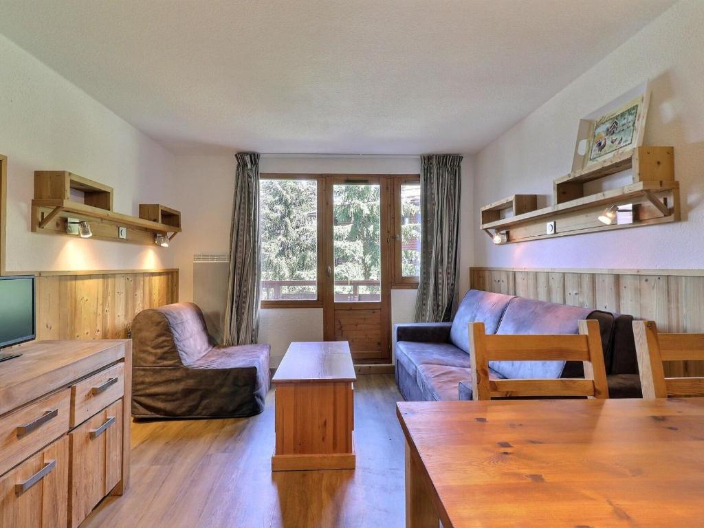 een woonkamer met een bank en een tafel bij Appartement La Tania, 2 pièces, 4 personnes - FR-1-182A-27 in Courchevel