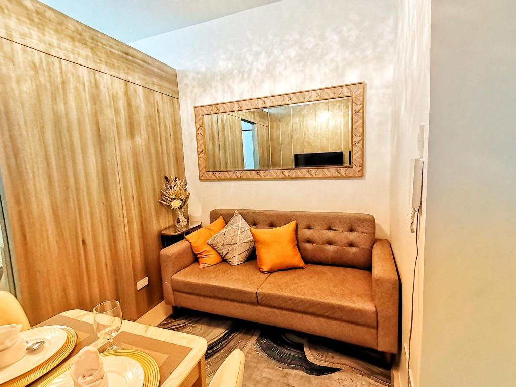 - un salon avec un canapé et un miroir dans l'établissement Stylish 1 Bedroom Condo Unit with Perfect Pool View Balcony at Fame Residences, à Manille