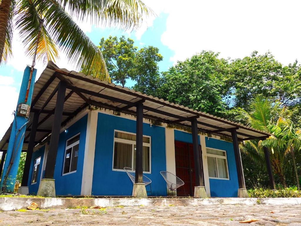 a blue and white house with a wooden roof at Casa 3 a 5 min del Irtra in Retalhuleu