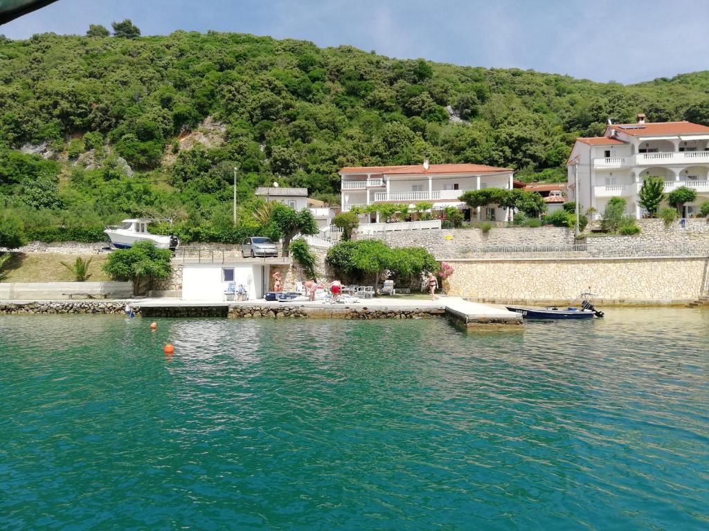 a large body of water with houses in the background at Apartments by the sea Supetarska Draga - Gornja, Rab - 2016 in Supetarska Draga