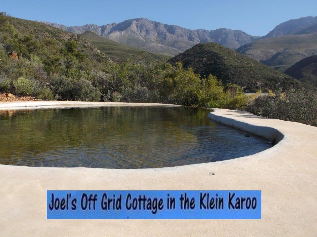 een bord dat warmwaterbronnen van beton in Khan korea leest bij Joel's Off Grid Cottage in the Klein Karoo in Oudtshoorn