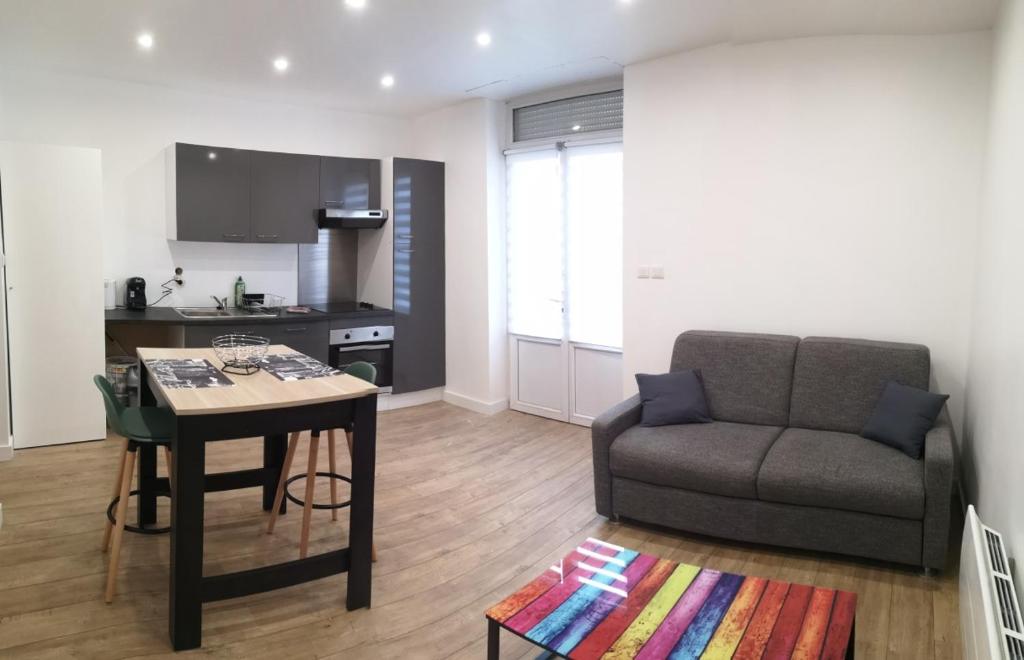 een woonkamer met een bank en een tafel bij LESAGE BIS in Lorient