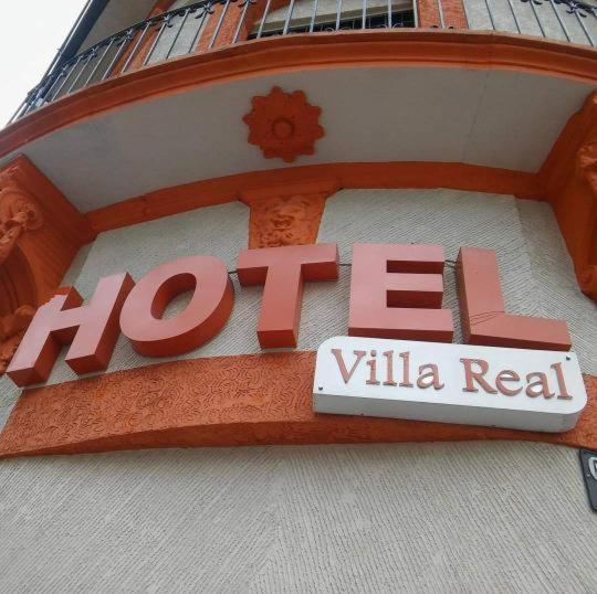 un cartel en un edificio que dice h el villa real en Hotel Villa Real en Bogotá