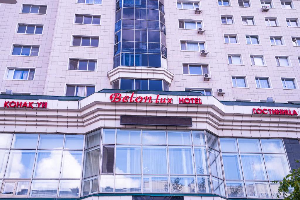 wysoki budynek z napisem na przodzie w obiekcie Belon Lux Hotel w mieście Astana