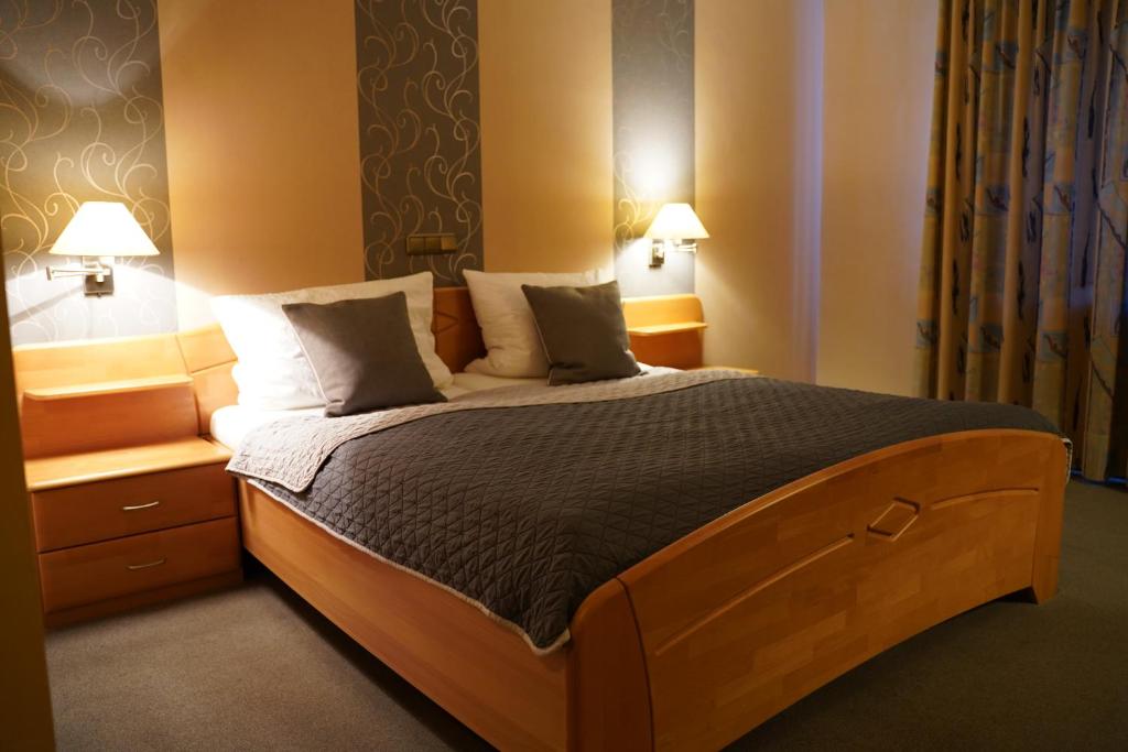 ein Schlafzimmer mit einem großen Bett mit zwei Nachttischen und zwei Lampen in der Unterkunft Gasthaus Heiko Sieb in Wischhafen