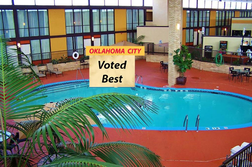 a large swimming pool in a building with a voted best sign at Wyndham Garden Oklahoma City Airport-4 Star Hotel Near I40, Fairgrounds, Paycom & Convention center 7 min to Bricktown! in Oklahoma City