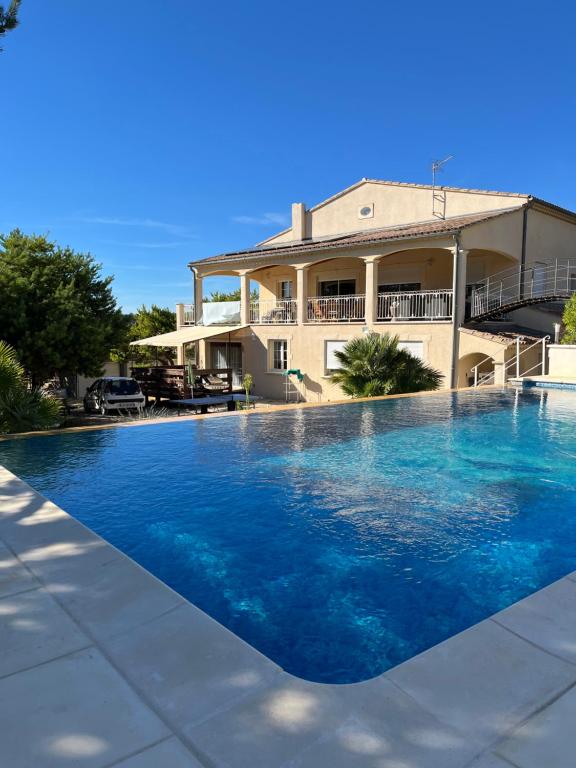 a large swimming pool in front of a house at Le Mas des Collines 2 personnes in Rousset-les-Vignes