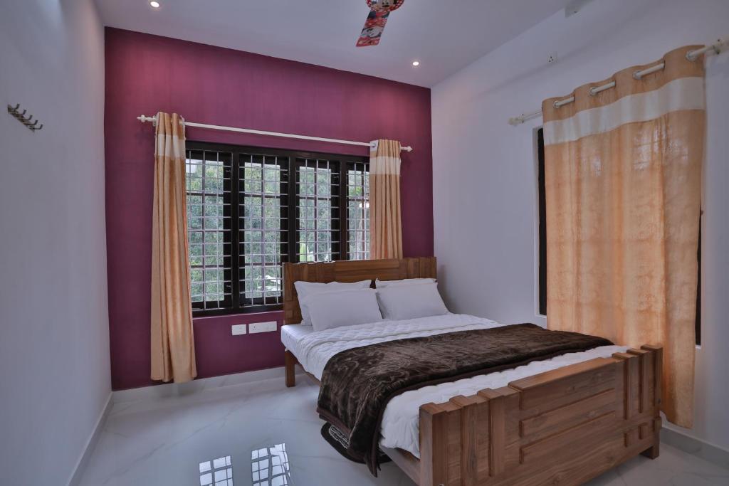 a bedroom with a bed and a purple wall at God's gift in Devikolam