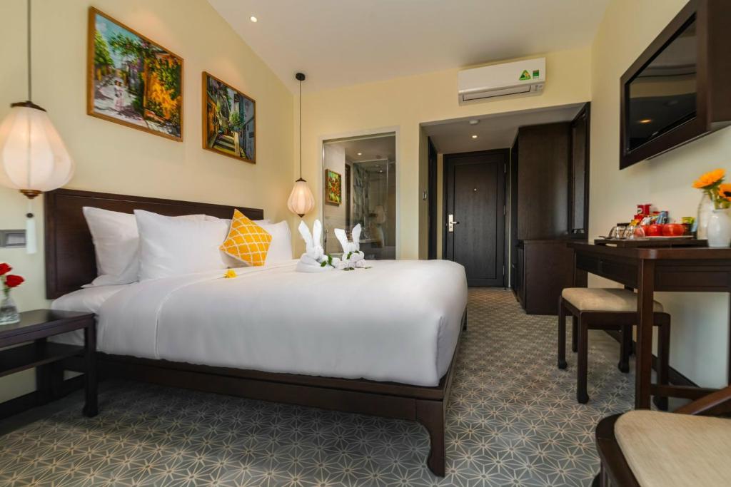 Postel nebo postele na pokoji v ubytování Hoi An Merrily De Art Hotel