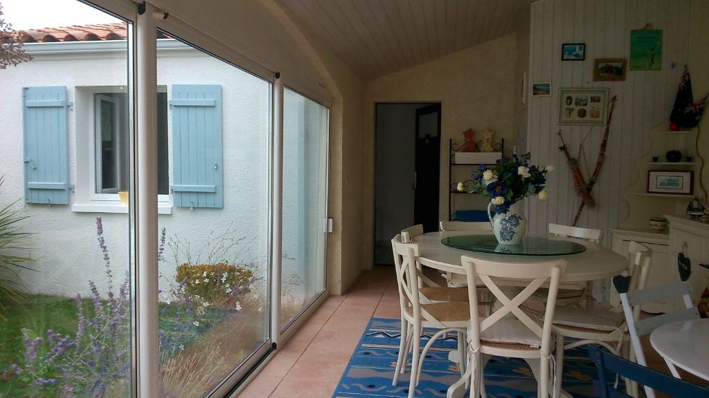 a dining room with a table and chairs in a house at Chambre d'Hôtes Armoise in Lagord