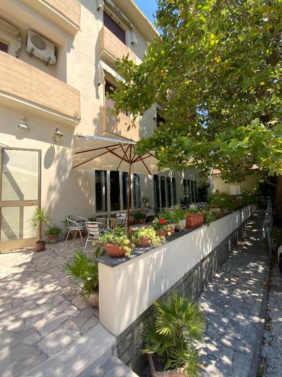 a retaining wall with potted plants and an umbrella at Hotel Naviglio in Marina di Pietrasanta