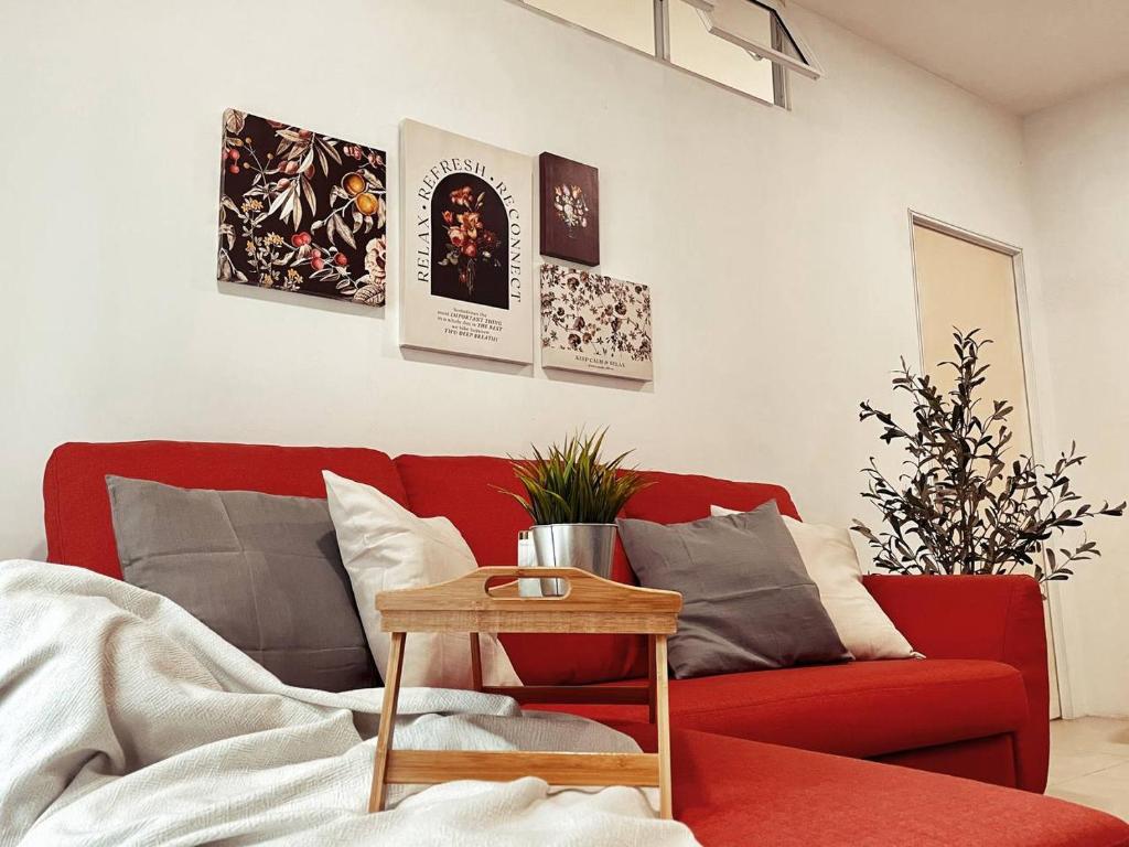 uma sala de estar com um sofá vermelho e uma mesa em Arcoris Mont Kiara 1~6 Pax Contemporary Living Netflix em Kuala Lumpur