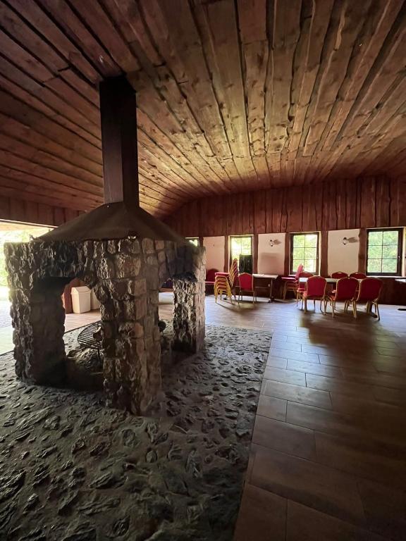a large room with a stone fireplace in a building at Chata Baryła in Sulęczyno