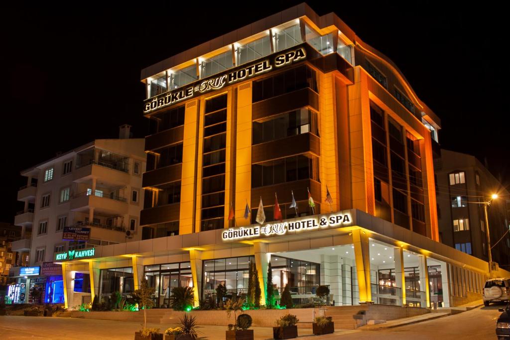 a building with a sign on top of it at night at Gorukle Oruc Hotel & Spa in Bursa