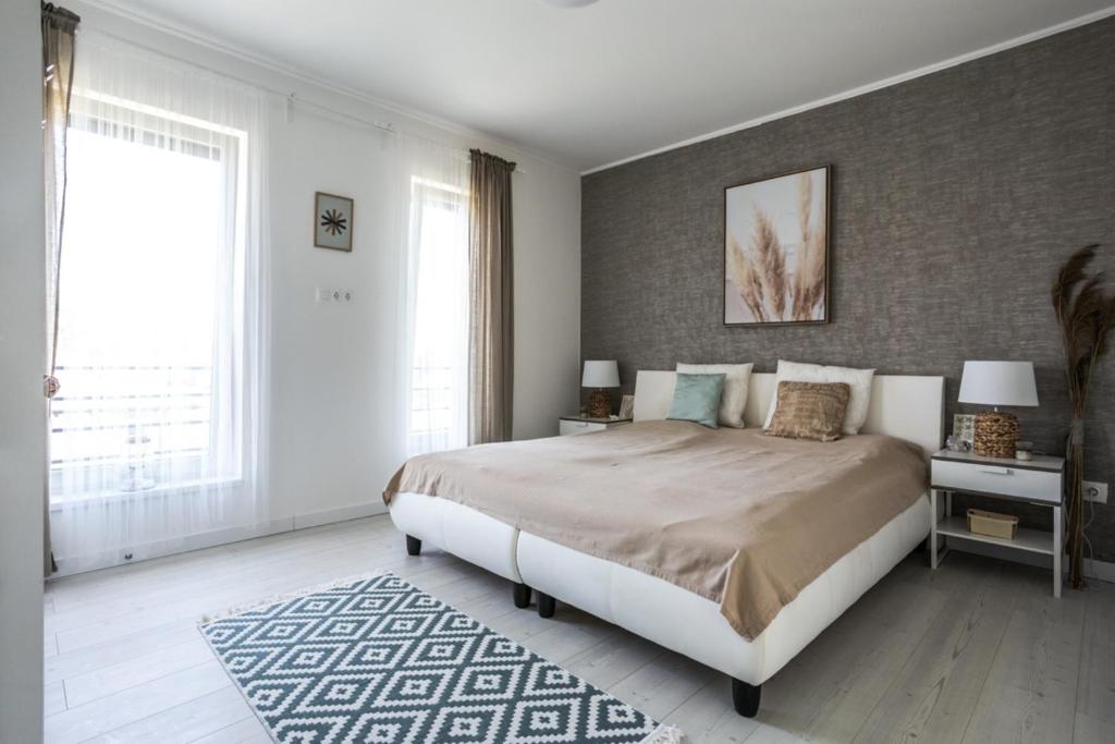 sypialnia z dużym łóżkiem i dużym oknem w obiekcie Dream Summer House Fonyód w mieście Fonyód