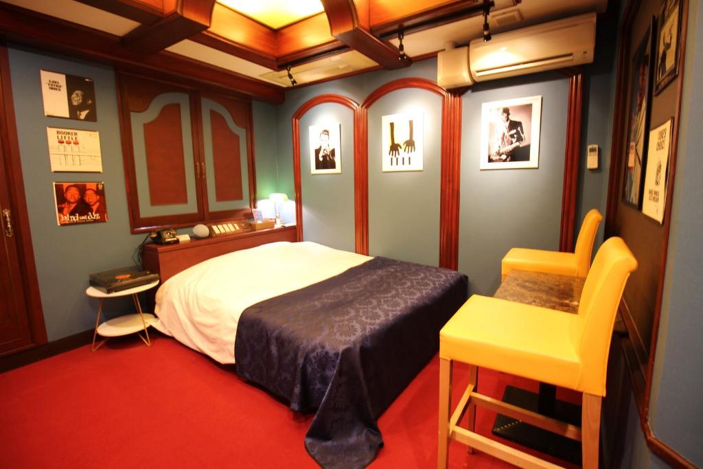 um quarto com uma cama e uma cadeira amarela em Hotel OLDSWING Adult Only em Tóquio