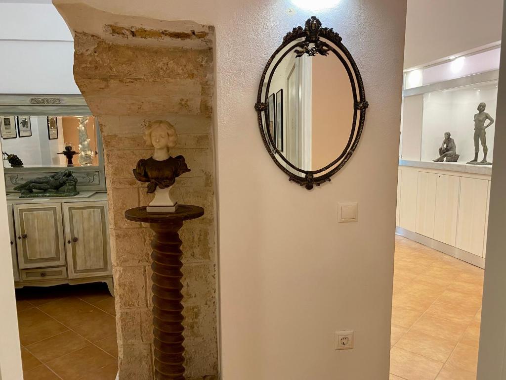 un miroir sur un mur à côté d'une chambre dans l'établissement RITSA ART RESIDENCE, à La Canée