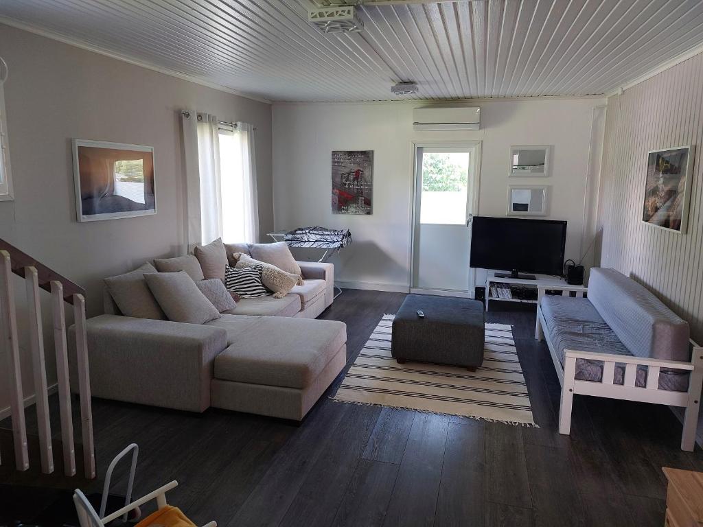 a living room with a couch and a tv at Villa Orismala in Isokyrö
