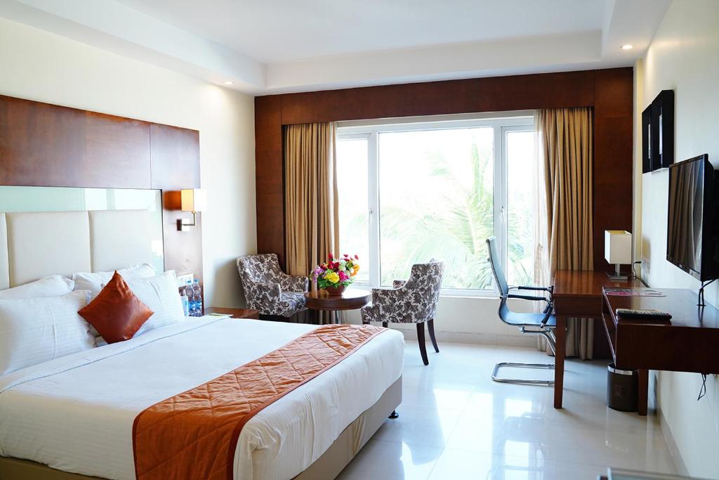 een hotelkamer met een bed, een bureau en een computer bij Quality Inn VIHA in Kumbakonam