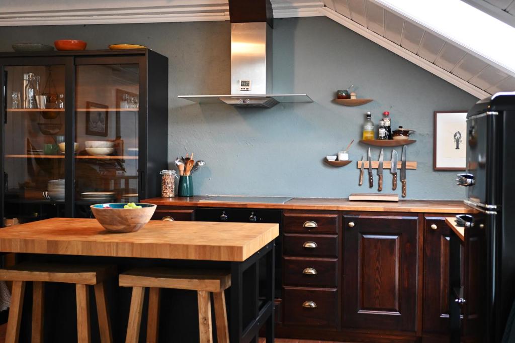 a kitchen with a wooden table and a black refrigerator at Sigurd's Loft in Vossevangen